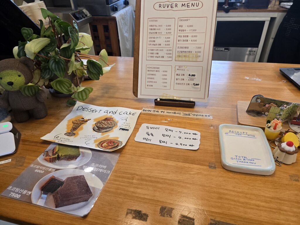 The cozy counter area and dessert menu board at Ruver Coffee in Jeonpo, Busan.